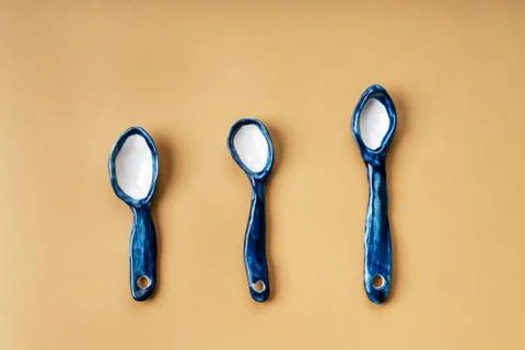 Three blue ceramic clay handmade spoons on a beige background Stock-Fotos