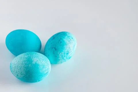 Three blue easter eggs on a light background. Stock Photos