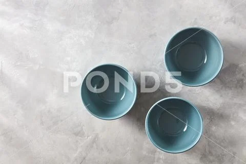 Three blue hand crafted chinese bowls on gray stone background. Flat lay Stock Photos