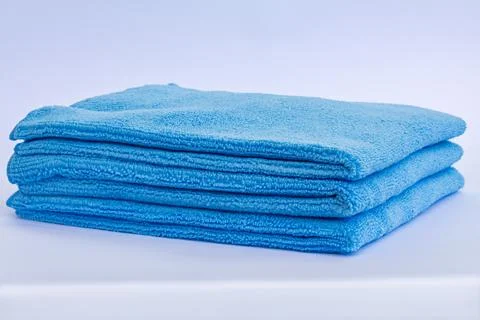 Three blue low pile height microfiber towels stack isolated on white backgrou 写真素材