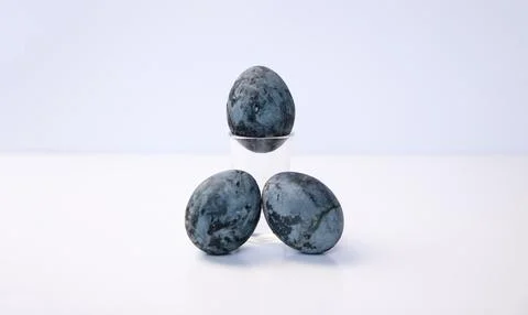Three blue marbled Easter eggs styled as cosmic or stone pattern on white b.. Foto stock