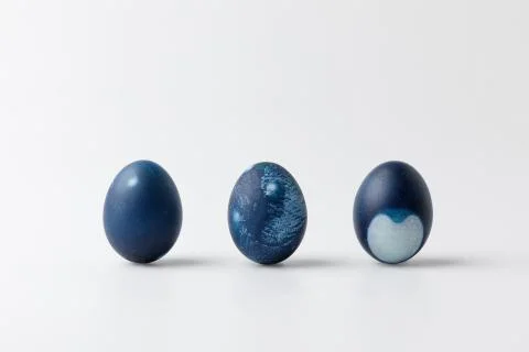 Three blue painted easter eggs on white surface 库存照片