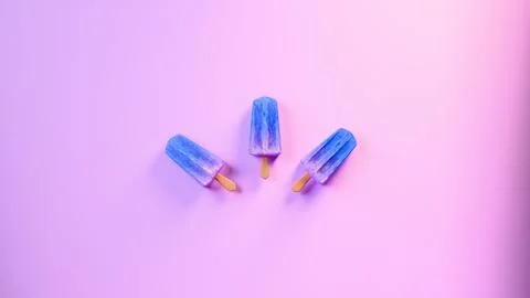 Three blue popsicles on purple background.... Foto stock