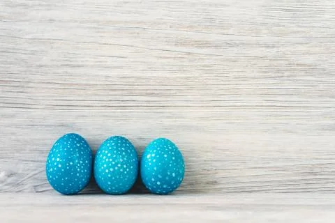 Three blue speckled Easter eggs on a white wooden background Foto stock
