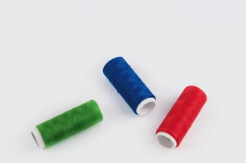 Three bobbin of colorful thread on white background Stock Photos