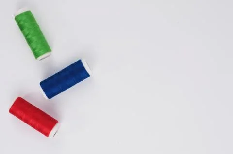 Three bobbin of colorful thread on white background. Top view Stock Photos