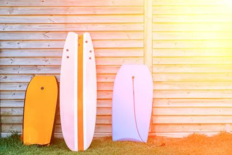 Three body boards of different sizes leaned against wooden shack - recreation Stock Photos
