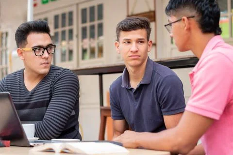 Three bored students in an open-air latin coffee shop. concept of premises Stock Photos