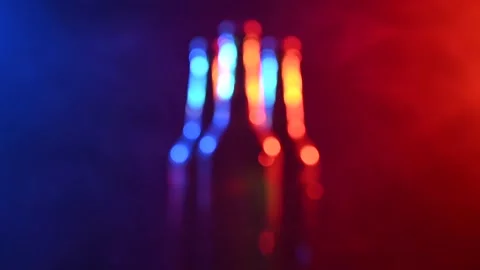 Three bottles of beer spinning in a blue-pink mist. Stock Footage 164609964