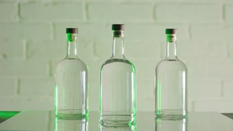 Three bottles of vodka stand against a brick wall Stock Footage 185189528