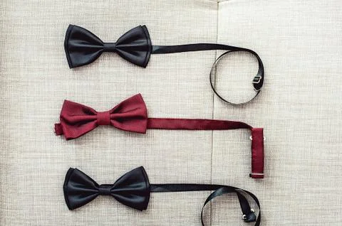 Three bow ties, two black and one red. Team work, career, hipster, wedding Stock Photos