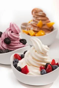 Three Bowls of Assorted Frozen Yogurt with Fruit Toppings Stock Photos