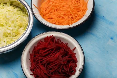 Three bowls of beetroot, carrots and cabbage cut into thin strips Stock Photos