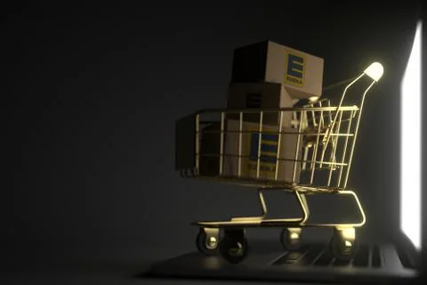 Three boxes with EDEKA logo in golden shopping cart on computer keyboard Stock Illustration