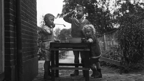 Three boys brothers blowing bubbles, historical photo 1923, zoom in Stock Footage 69851664