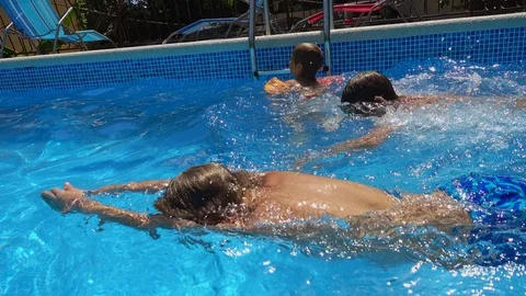 Three boys swimming in the pool Stock Footage 103936410