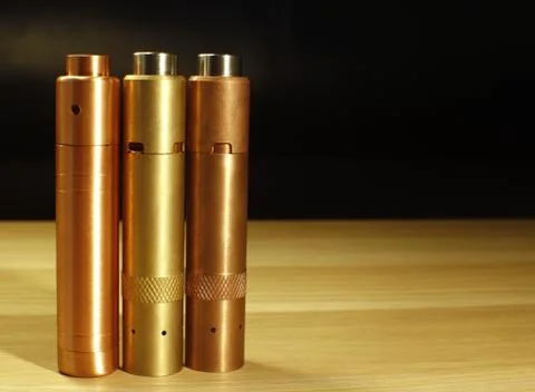 Three brass and copper mechanical mods for vaping (electronic cigarette) on.. Stock Photos
