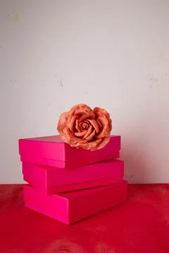 Three bright pink present boxes, fabric rose flower on wooden background Stock Photos