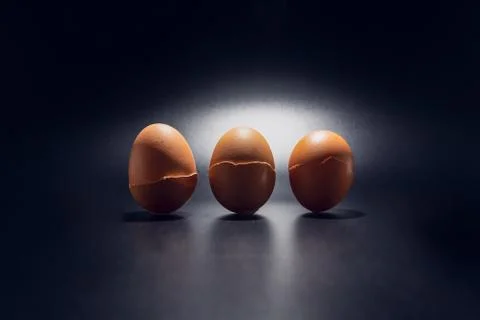 Three broken chicken egg shells in line isolated on black background  Stock Photos