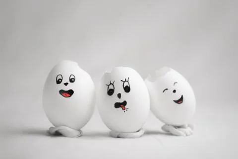 Three broken eggs with funny emoticons Stock Photos