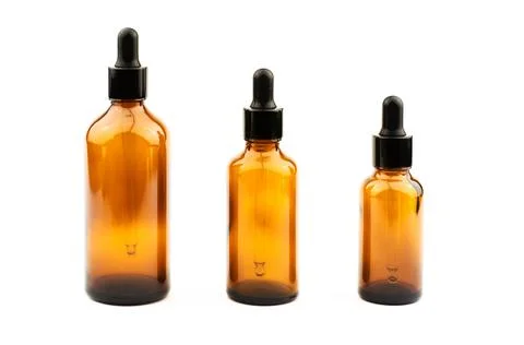 Three brown bottles with a dropper of different sizes for essential oils Stock Photos