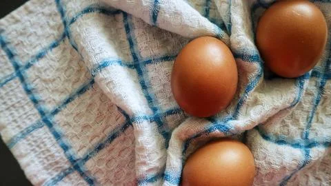 Three Brown Eggs on a Checkered Kitchen Towel Stock Photos