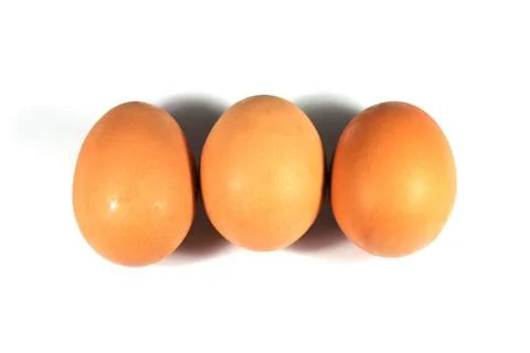 Three brown eggs isolated on white background. Stock Photos