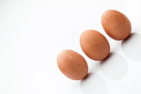 Three brown eggs isolated on a white background. Stock Photos