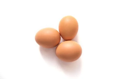Three brown eggs isolated on the white background. Stock Photos