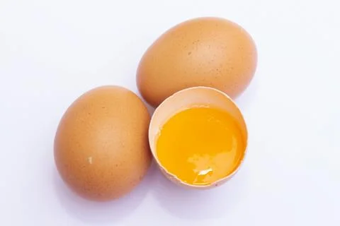 Three brown Eggs with one has broken isolated on white background Stock Photos