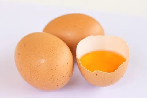 Three brown Eggs with one has broken isolated on white background Foto stock