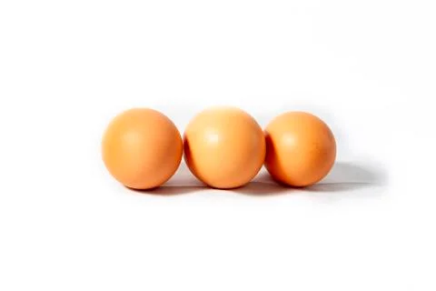 Three brown eggs on a white background. Stock Photos