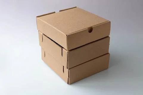 Three brown narrow cardboard boxes on a white background Stock Photos
