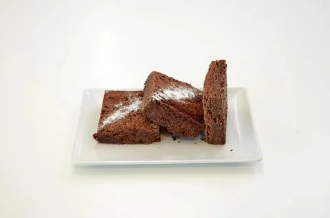 Three brownies on a white plate Stock Photos