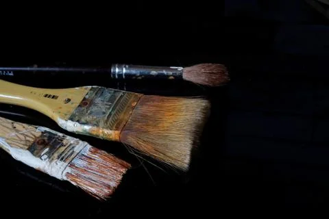 Three brushes on black surface. Stock Photos