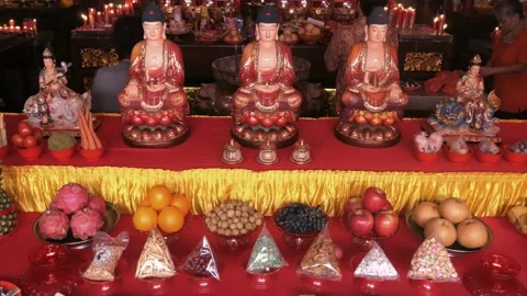 Three Buddha statues, offerings and people Stock Footage 148724683