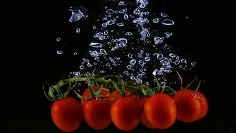 Three bunches of cherry tomatoes dropping into the water in slow motion. 스톡 동영상 77002479