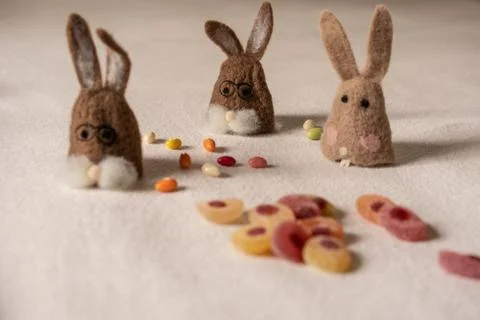 Three bunnies sitting between candys. Stock-Fotos