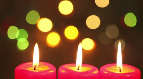 Three burning candles. against the backdrop of flashing garland Stock Footage 67358333