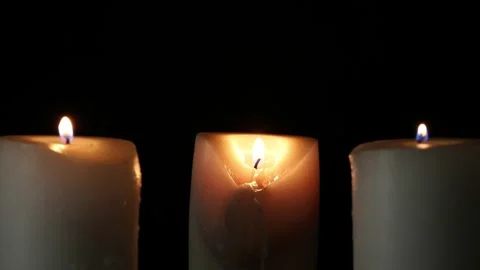 Three burning candles on the oak stand in the dark Stock Footage 306947210