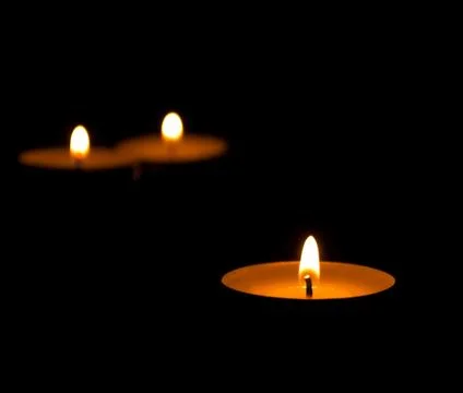 Three burning candles with reflection on black background Stock Photos