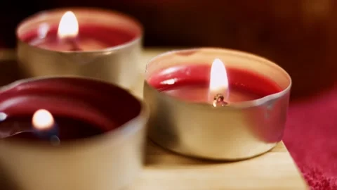 Three burning tea lights candles. Creating beautiful atmospere with candles. 4K Stock Footage 145712967