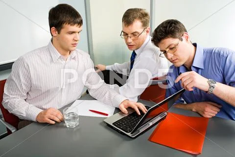Three business men working together on laptop in the office Stock Photos