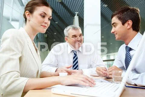 Three business partners sitting in office and planning work Stock Photos