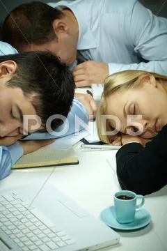 Three business people falling asleep in office Stock Photos