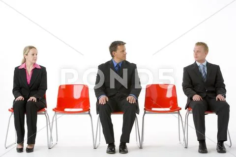Three Business People Sitting On Red Plastic Seats Stock Photos