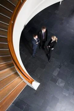 Three business people standing in the lobby of a building Stock Photos