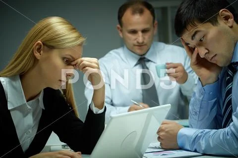 Three business people working late in office Stock Photos