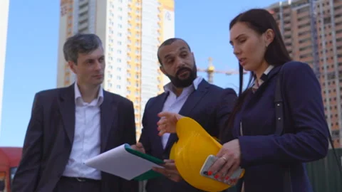 Three businessmen an architect and an engineer are standing at a construction Stock-Footage 89430733