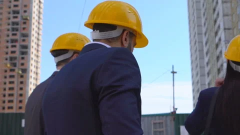 Three businessmen an architect and an engineer are standing at a construction Stock Footage 89431296